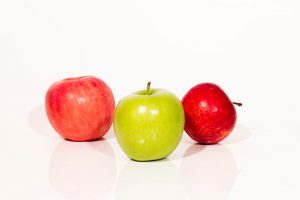 Grüner Apfel unter roten Äpfeln