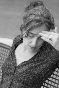 Sabria nachdenklich mit Hand an der Stirn