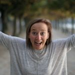 Daniela mit ausgestreckten Armen vor Baumallee