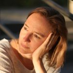 Daniela auf der Treppe schaut in die Sonne