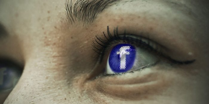 Augen in Nahaufnehme, in deren Iris das Facebooklogo leuchtet