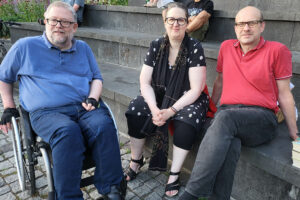 Thomas, Annette und Michael sitzen im Amphitheater der Beueler Rheinpromenade