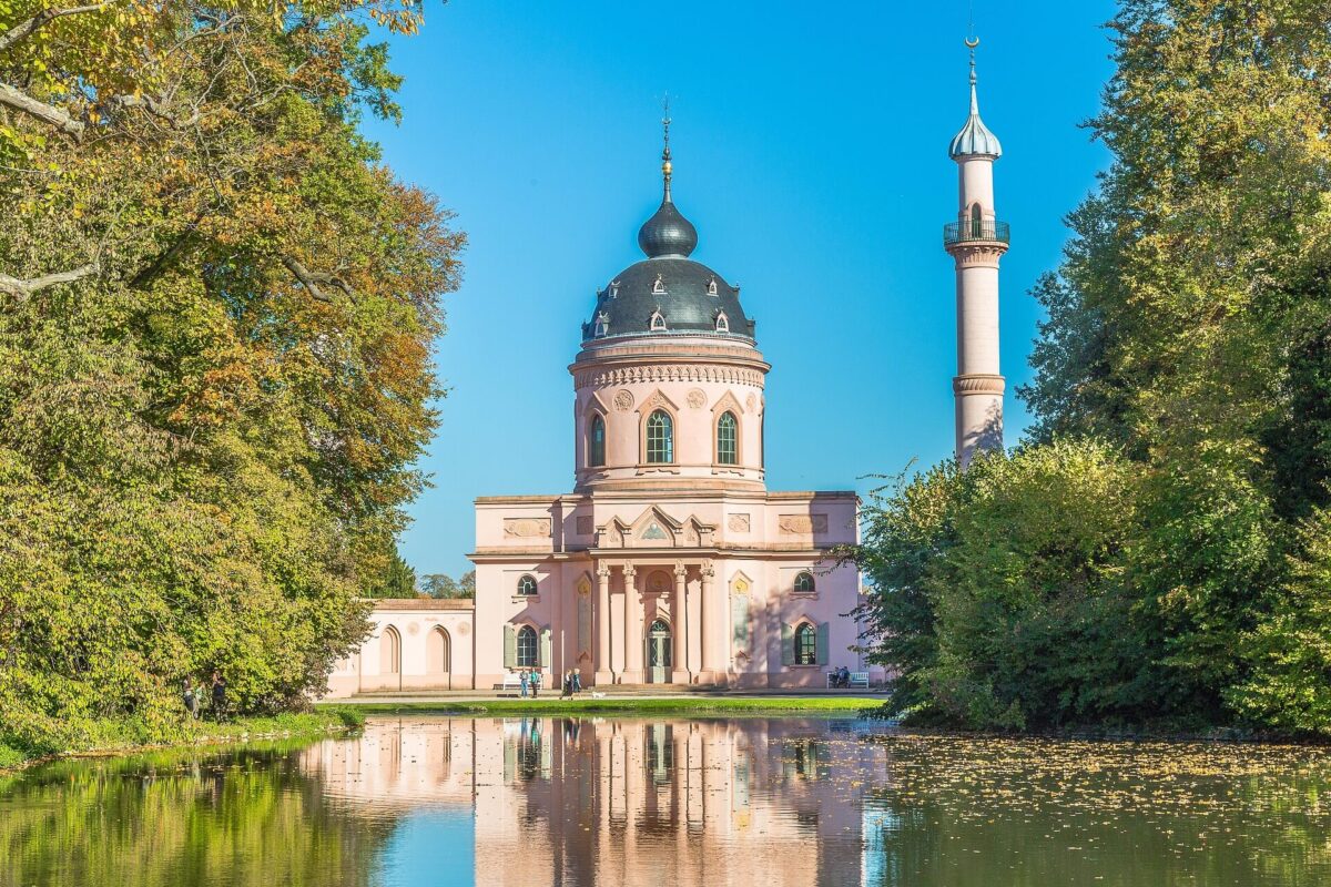 Blick über einen See im Schwetzinger Schlossgarten auf die Moschee, die sich im Wasser spiegelt