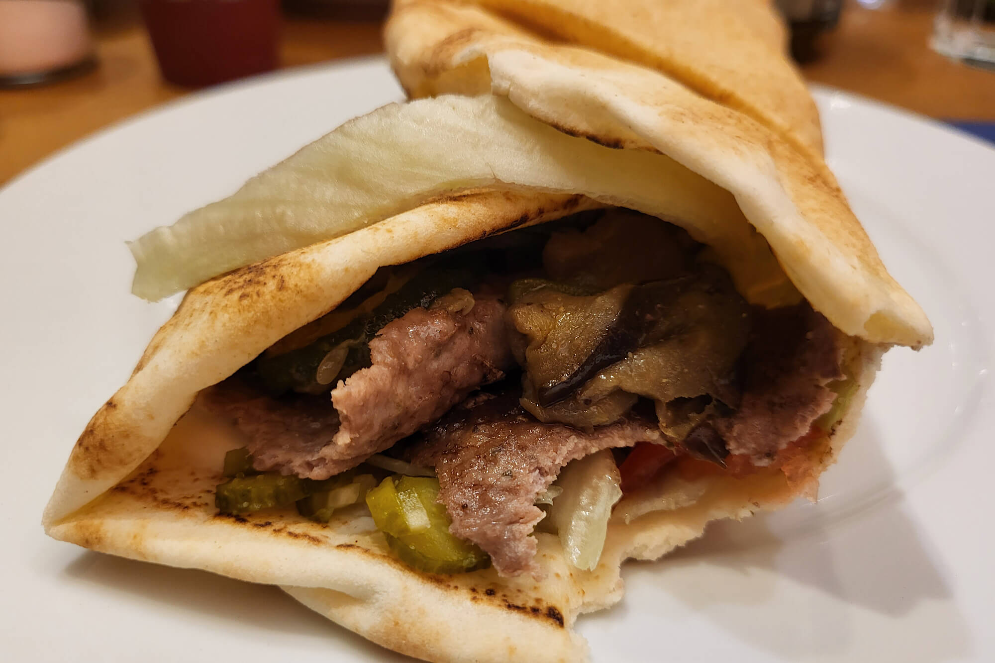 Großaufnahme in die Dönerrolle hinein, so dass man das Fleich und Gemüse sehen kann