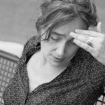 Sabria nachdenklich mit Hand an der Stirn