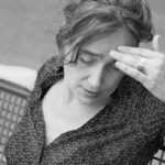 Sabria nachdenklich mit Hand an der Stirn