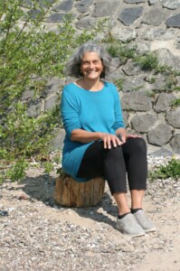 Christine sitzt am Ufer