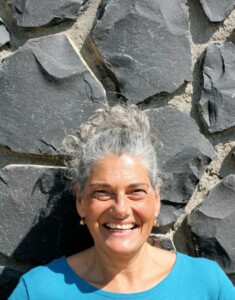 Christine mit Zopf vor Steinmauer