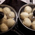 Dampfnudeln durch die Glasdeckel beim Ausbacken in zwei nebeneinanderstehenden Pfannen fotografiert
