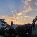 Gegenlichtaufnahme Hinterhöfe mit golden leuchtenden Wolken und sichtbaren Sonnenstrahlen